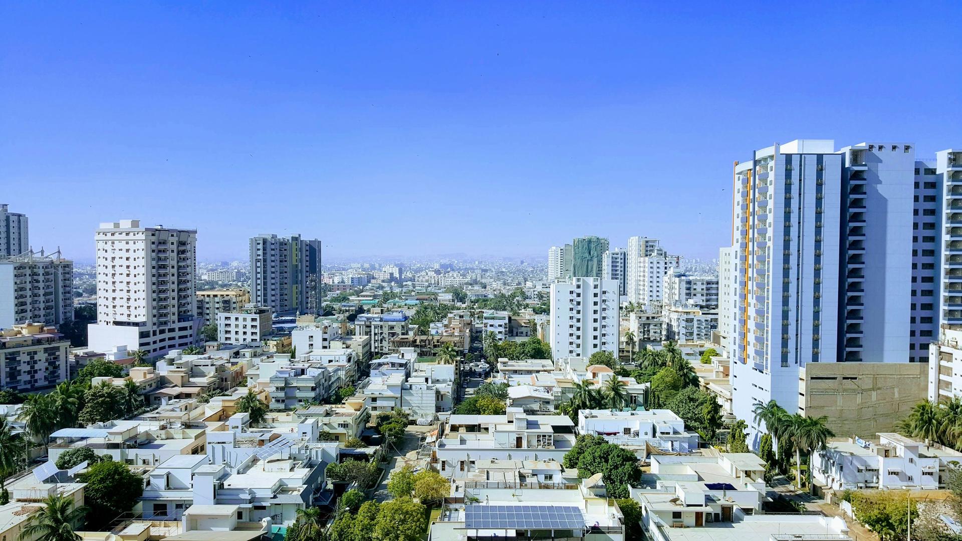 Elevated view across a city of mid- and high-rise buildings under a blue sky